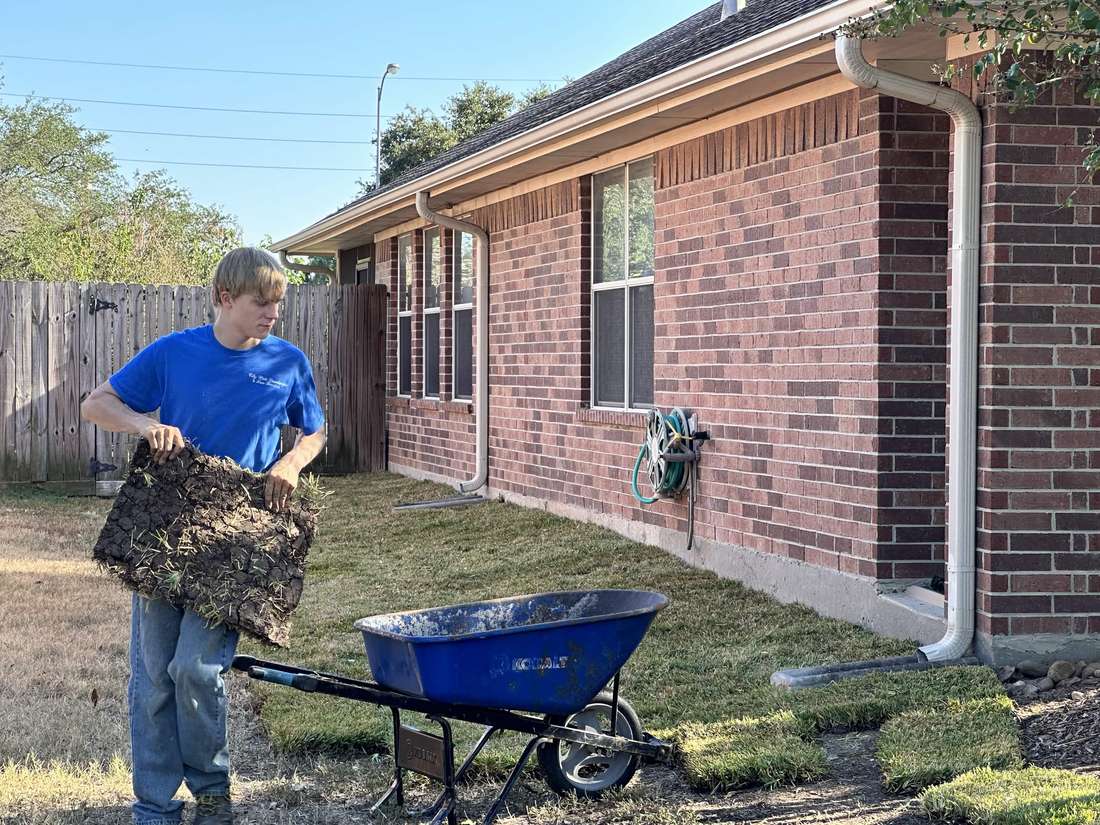 Jacob Swindle spreading mulch at a residential property